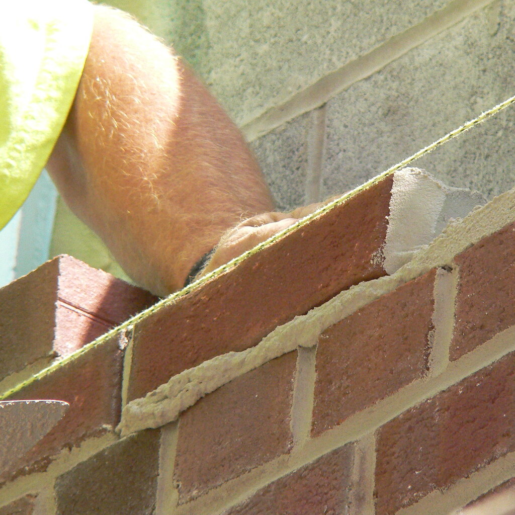 Photo of someone laying a brick