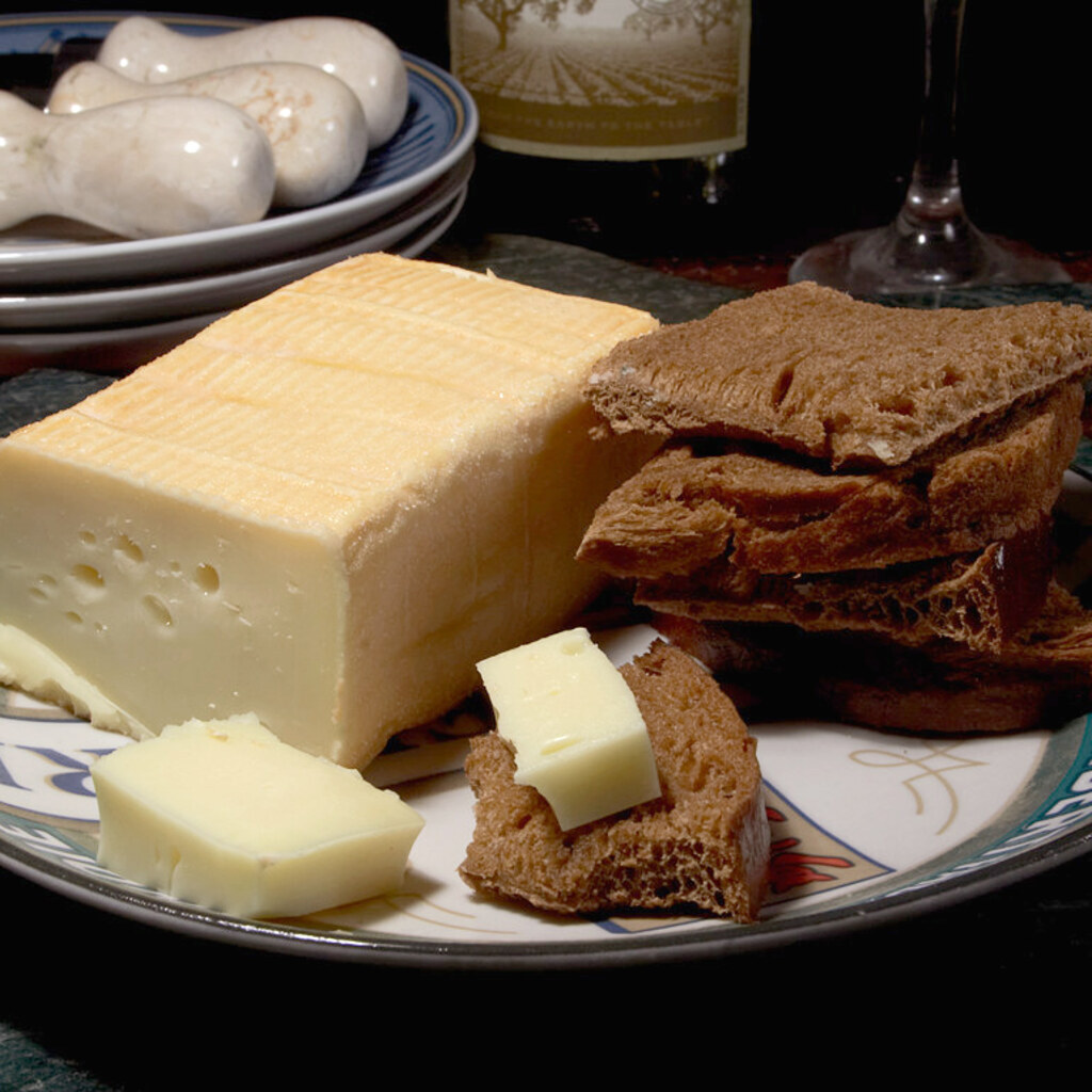 A photo of a block of Limburger cheese served with dark bread.