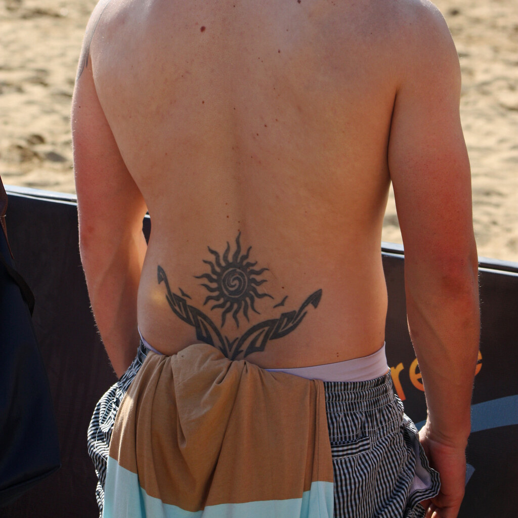 Photo of a man with a tattoo on his lower back