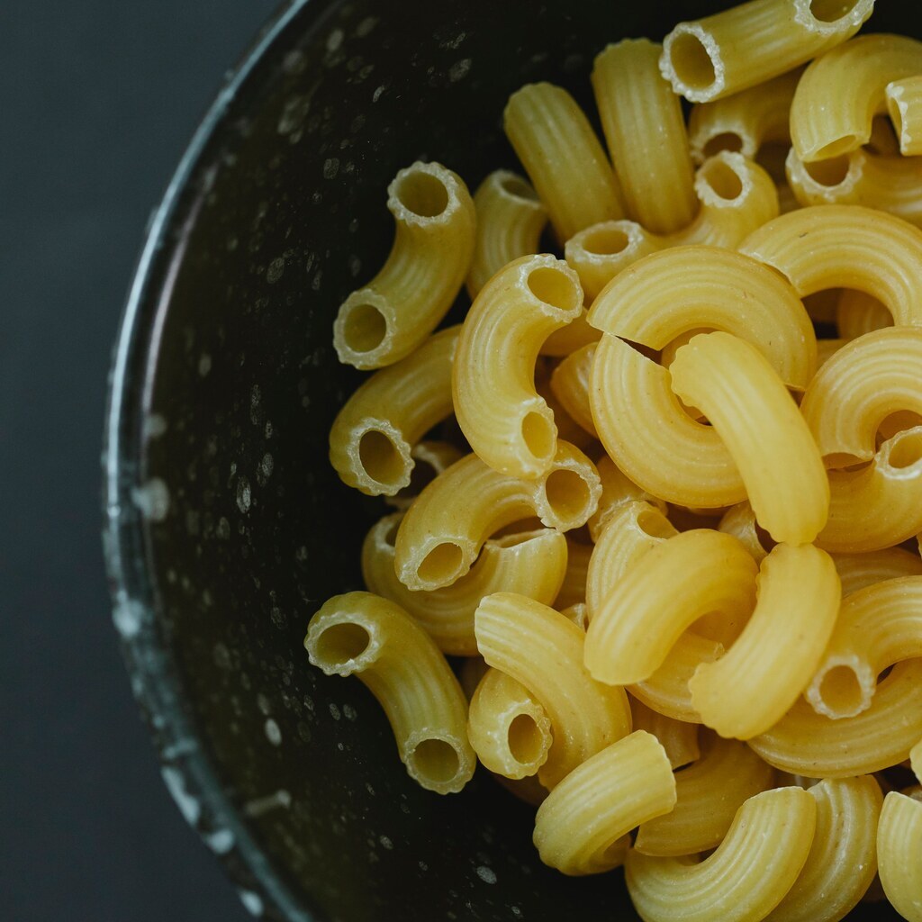 A photo of uncooked elbow macaroni in a bowl.