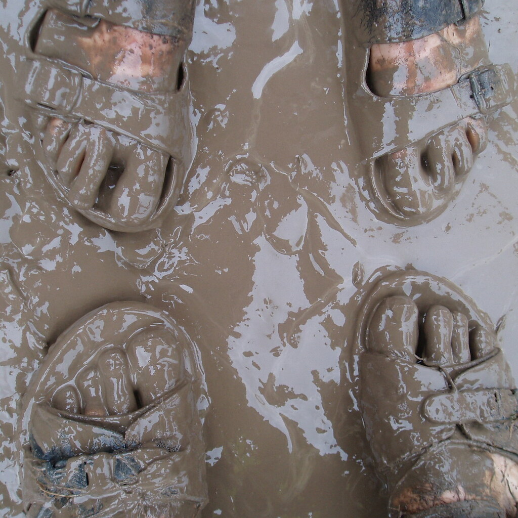 Photo of some people standing in mud.