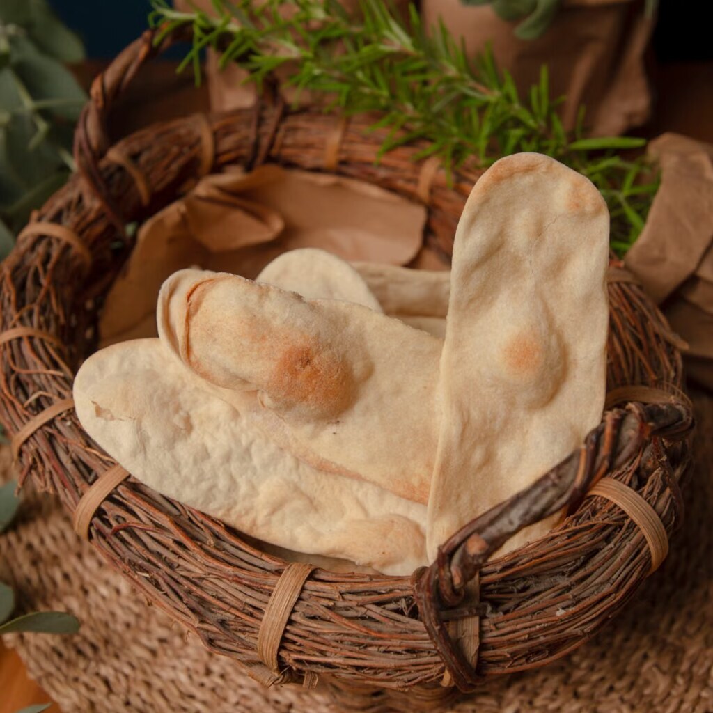 A photo of freshly baked naan bread in a basket.