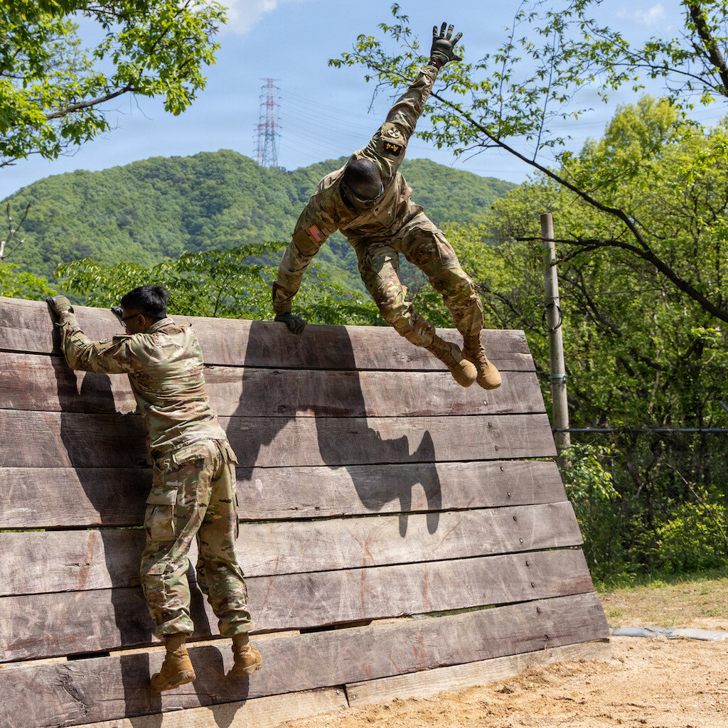 Photo of soldiers climbing over a wall