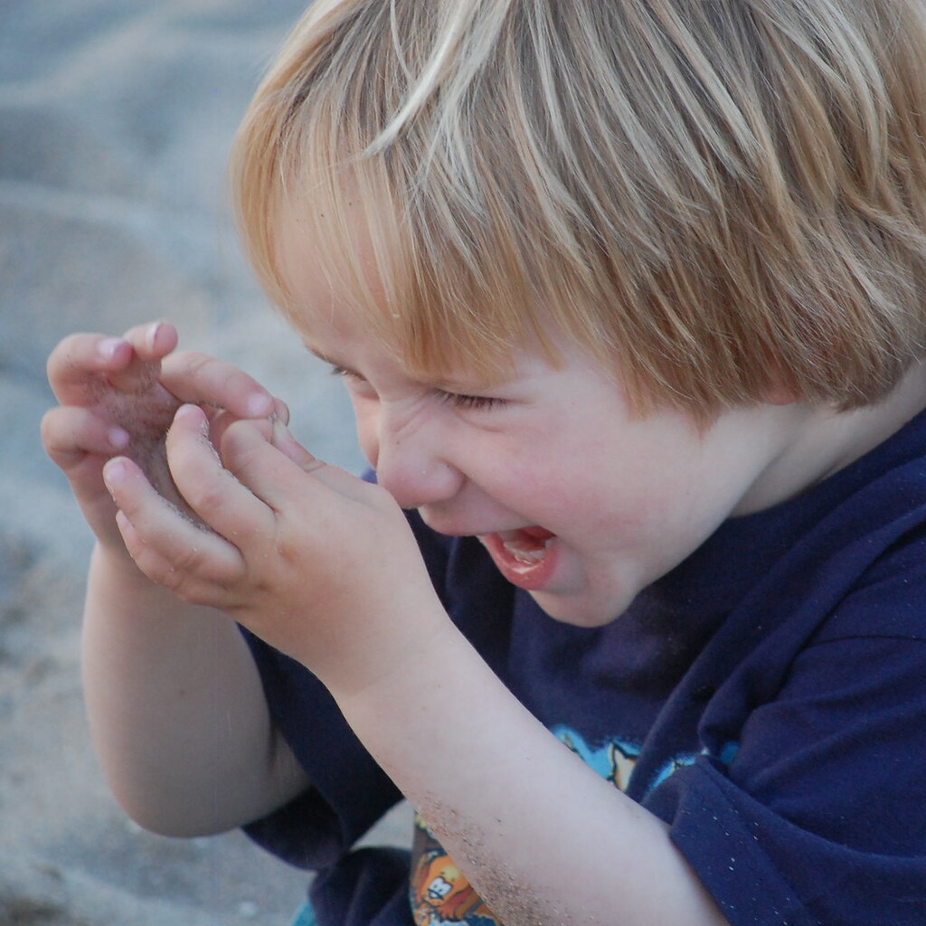 Photo of a child examining some grains of sand