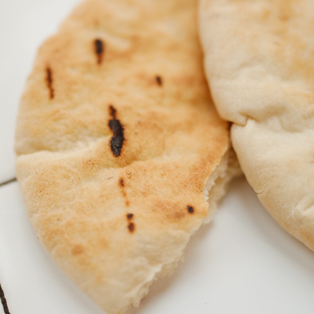 A photo of two pita breads on a white surface.