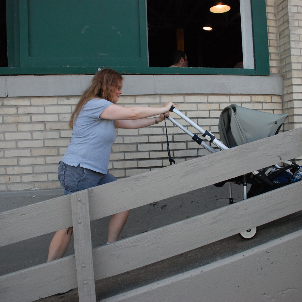 Photo of a woman pushing a pram up a ramp
