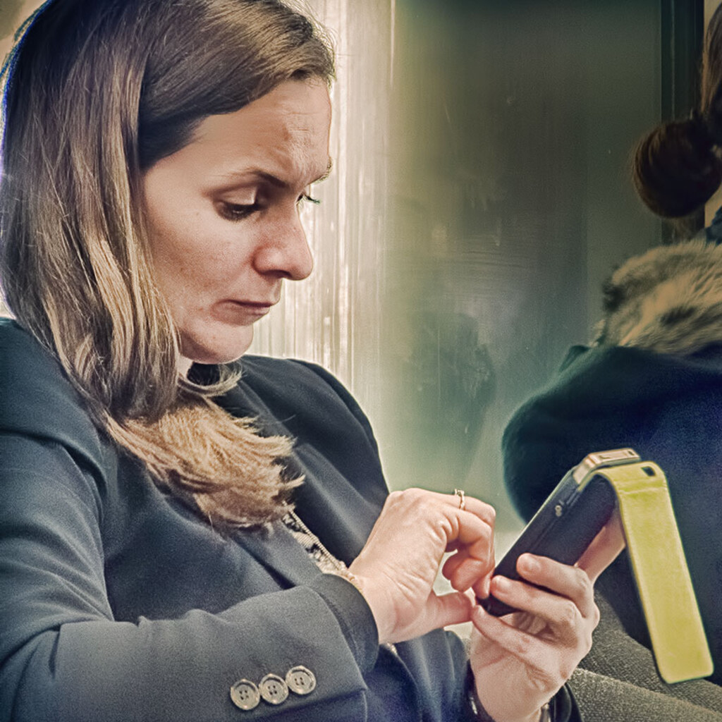 Photo of a woman rapt by her phone