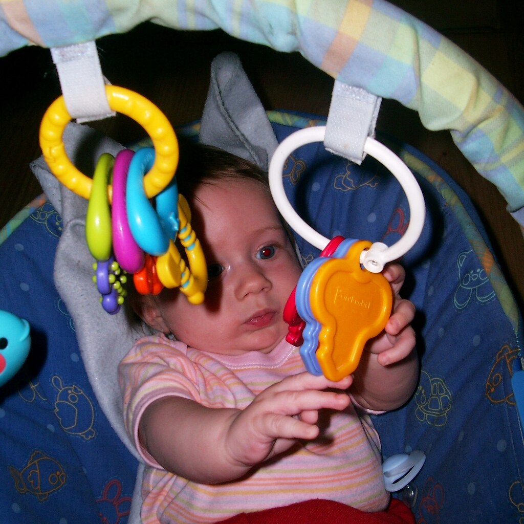 Photo of a baby and some hanging rattles