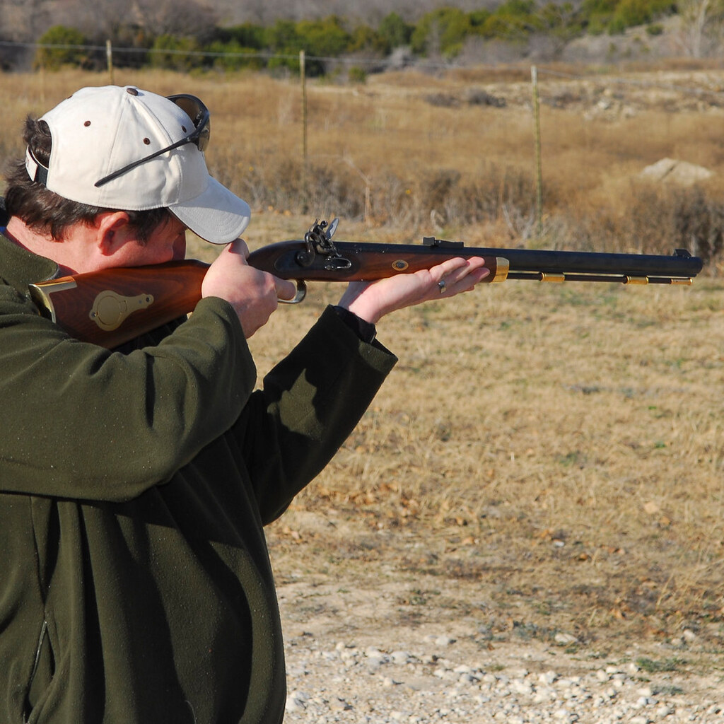 Photo of a man aiming a rifle.