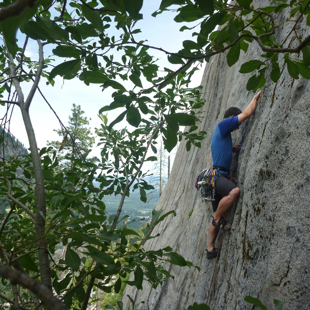 Photo of a man climbing a steep cliff