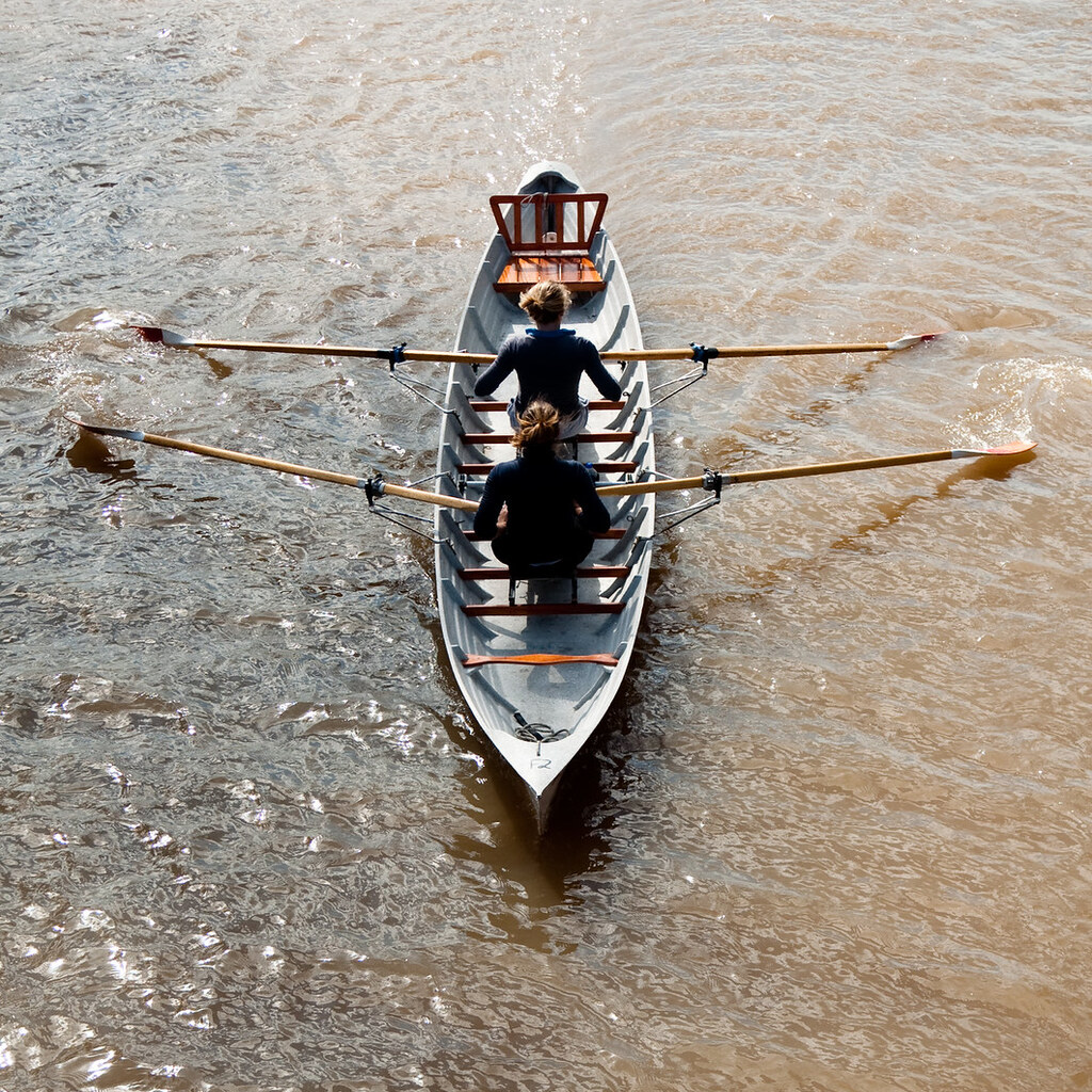 Photo of people rowing a boat.