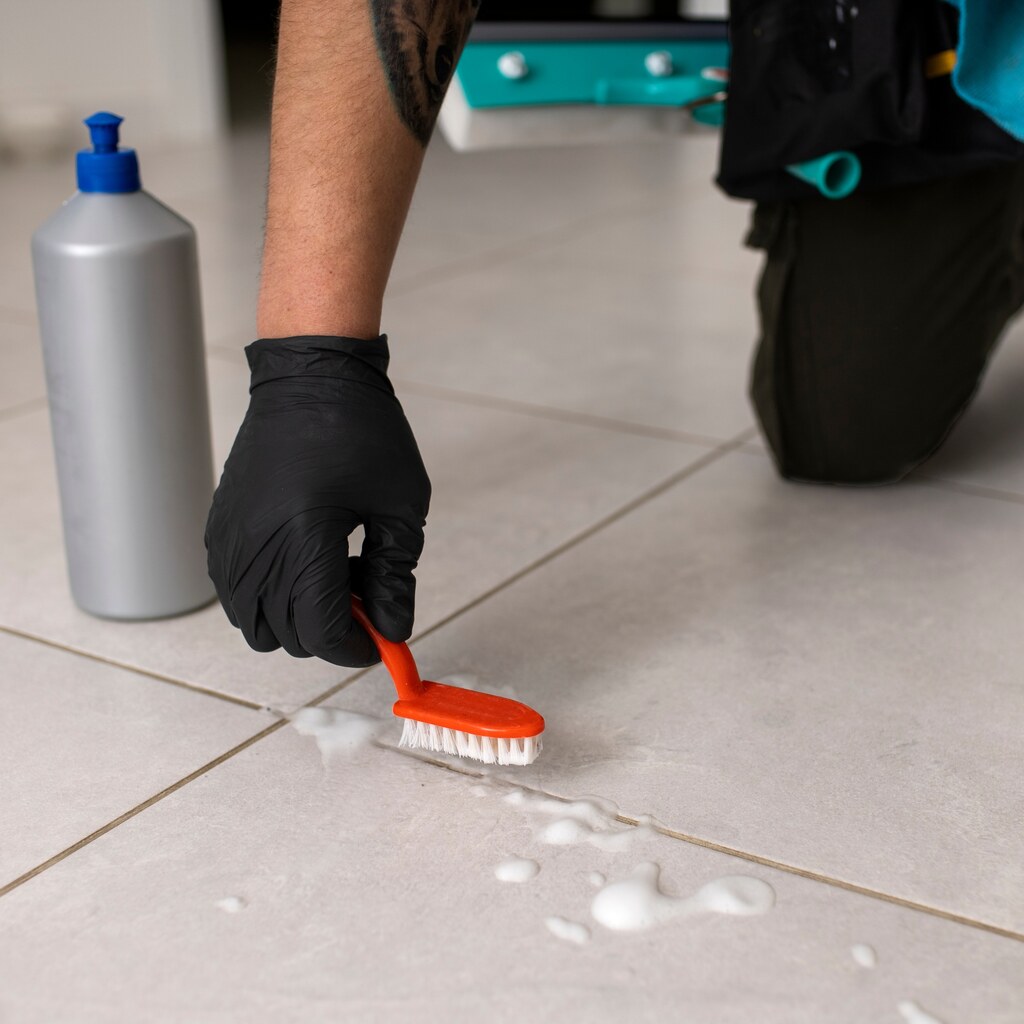 Photo of a someone scrubbing grout