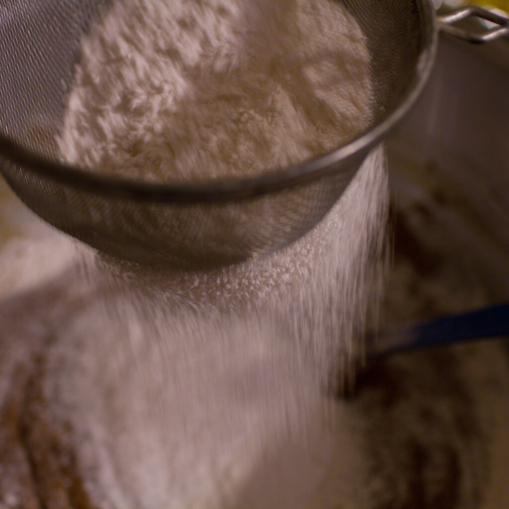Photo of someone sifting flour.