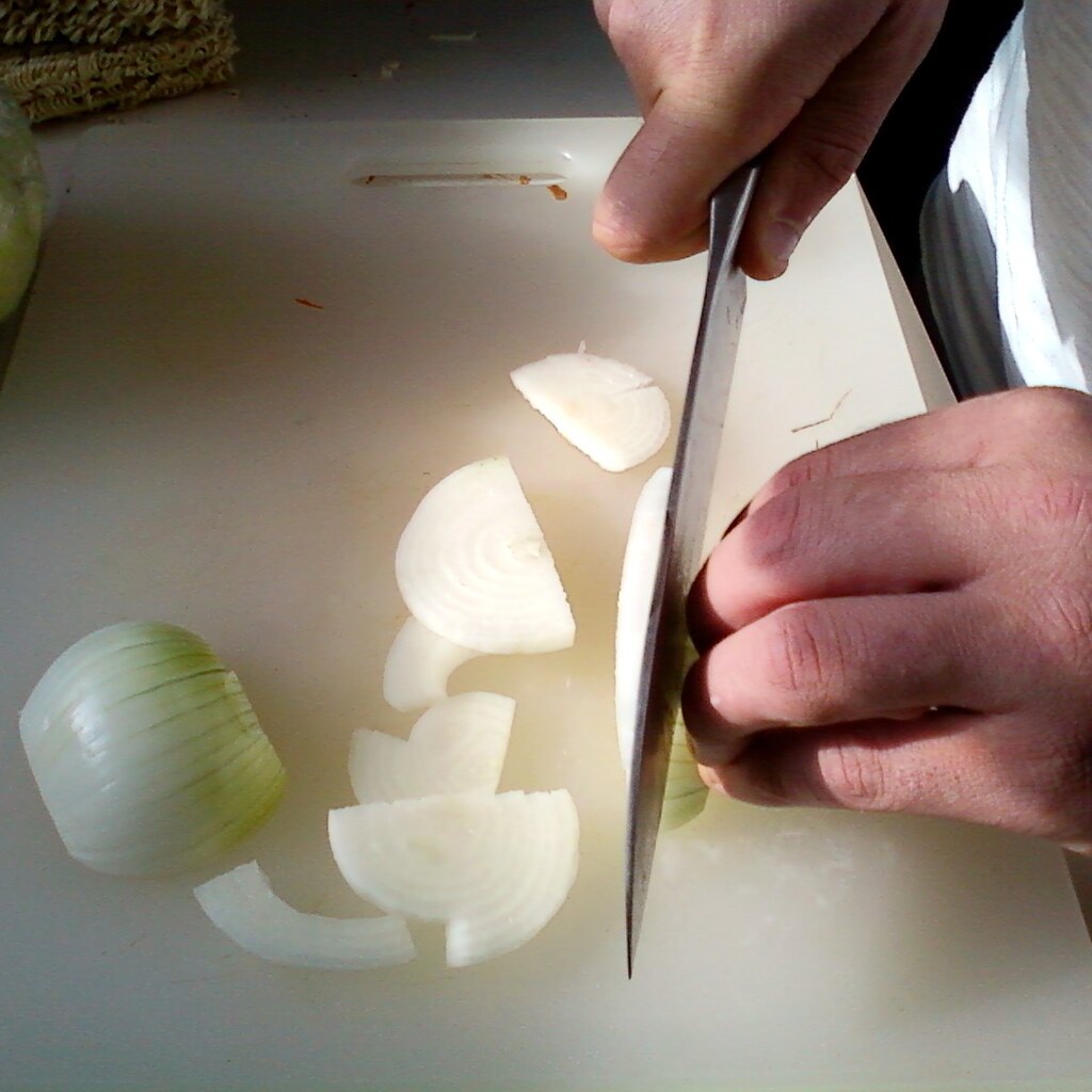 Photo of someone slicing onions