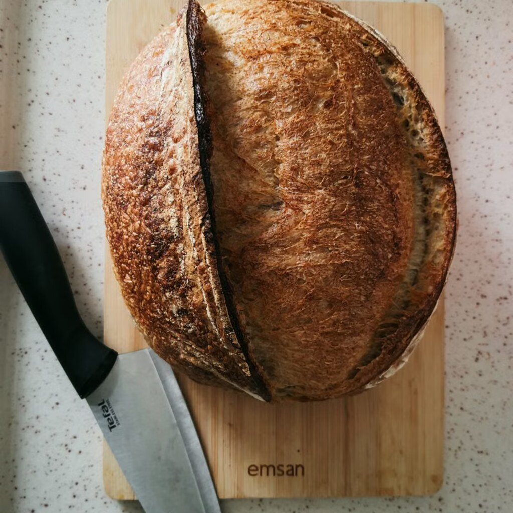 A round loaf of sourdough bread on a cutting board