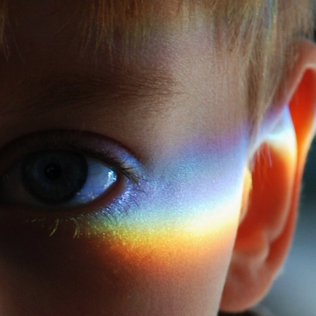 Photo of a boy with a rainbow on his face