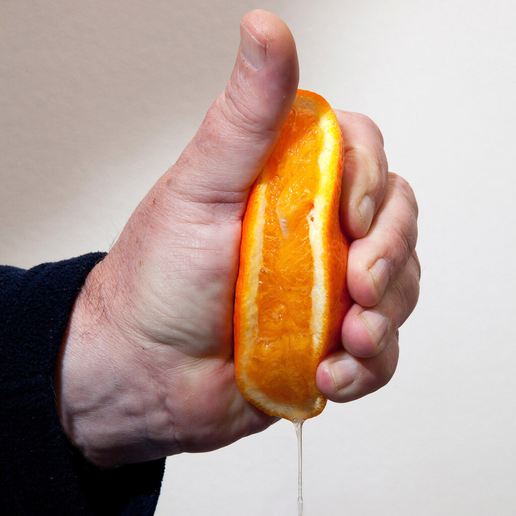 Photo of someone squeezing an orange