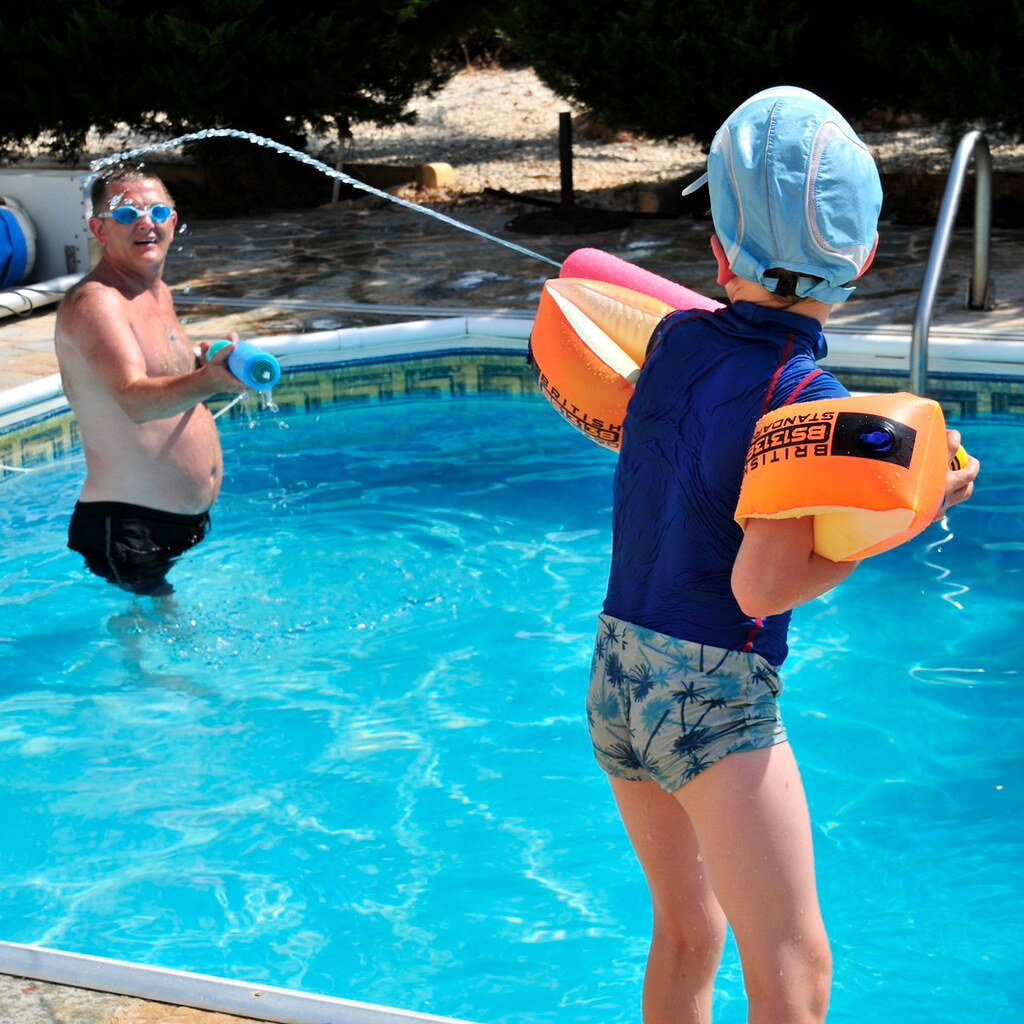Photo of a child squirting their parent with a water gun
