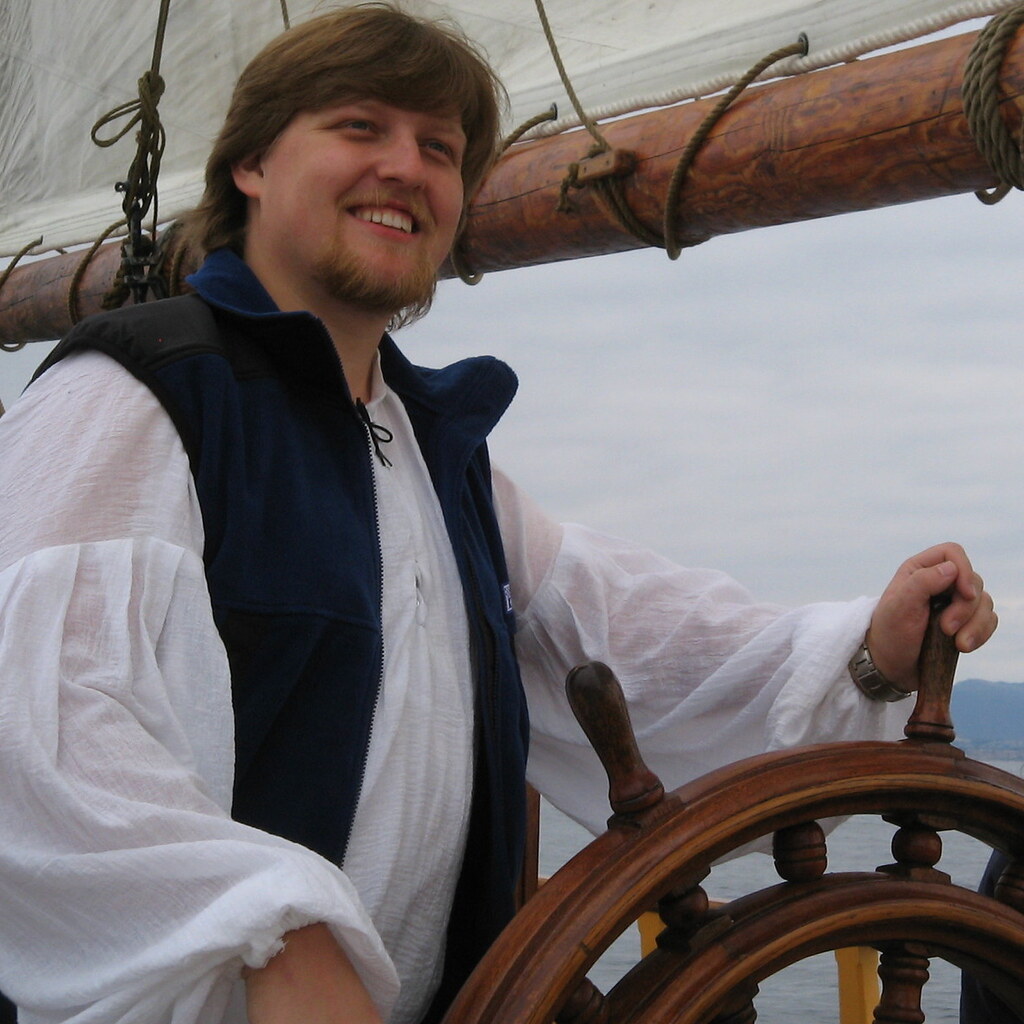 Photo of a man steering a ship