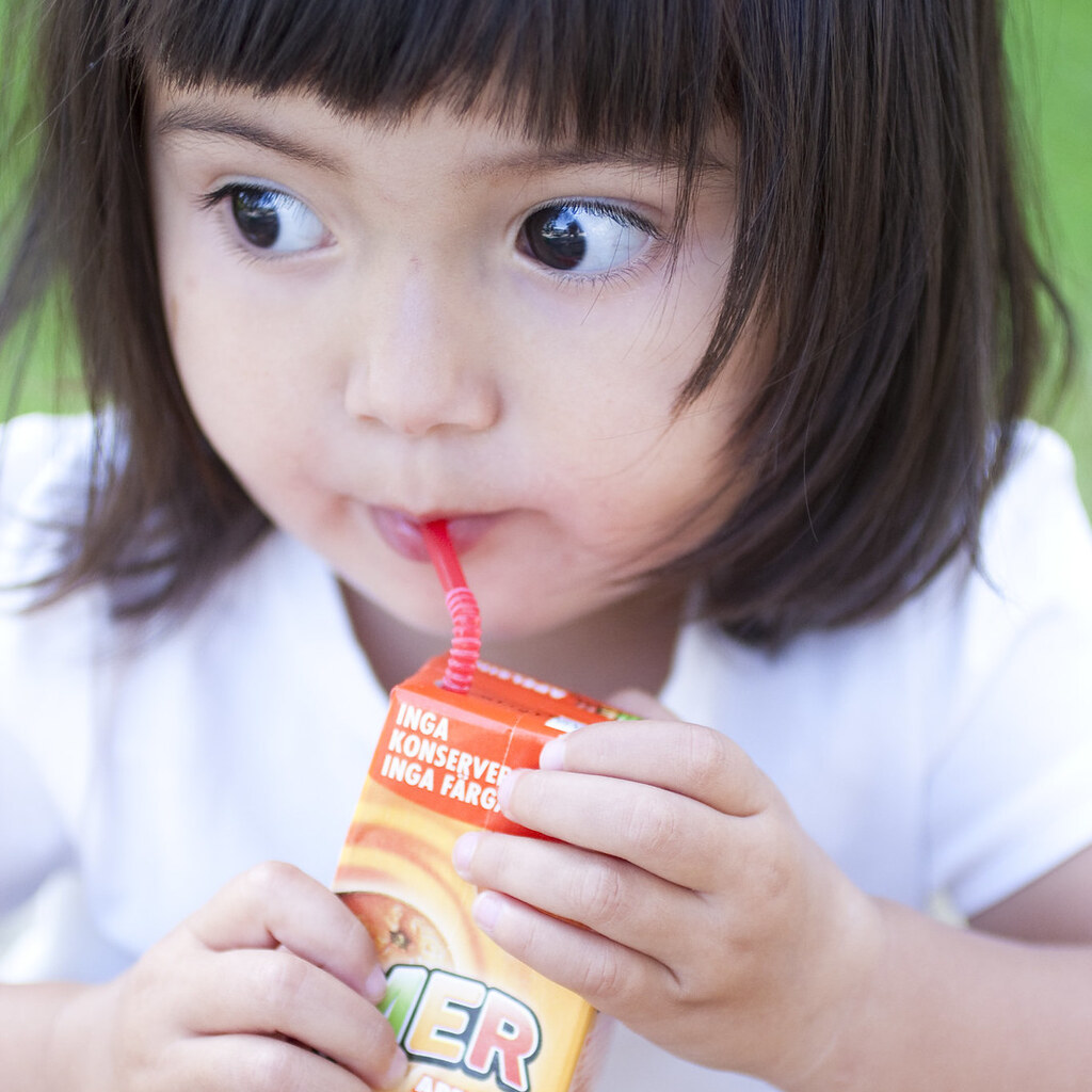 Photo of a little girl sucking through a straw