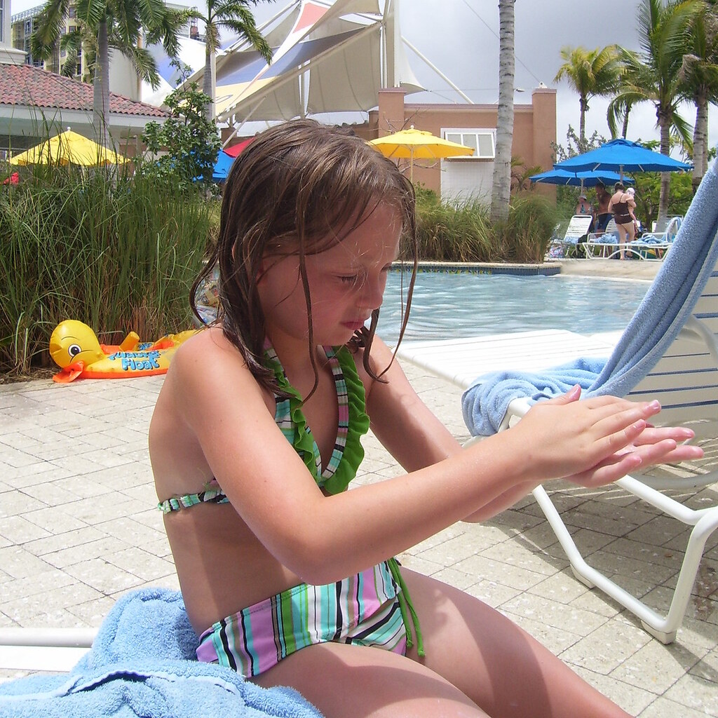 Photo of a girl applying sunscreen