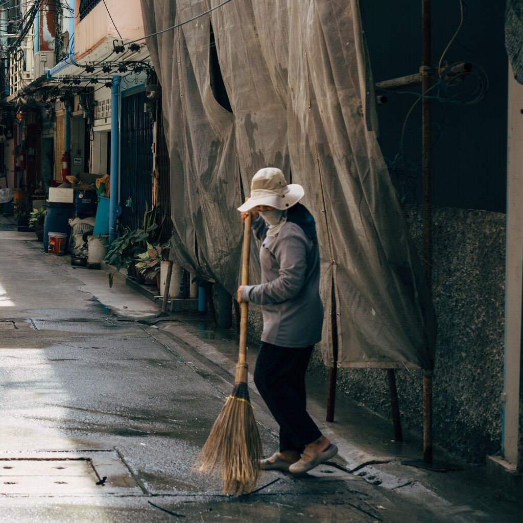 Photo of a woman sweeping the road