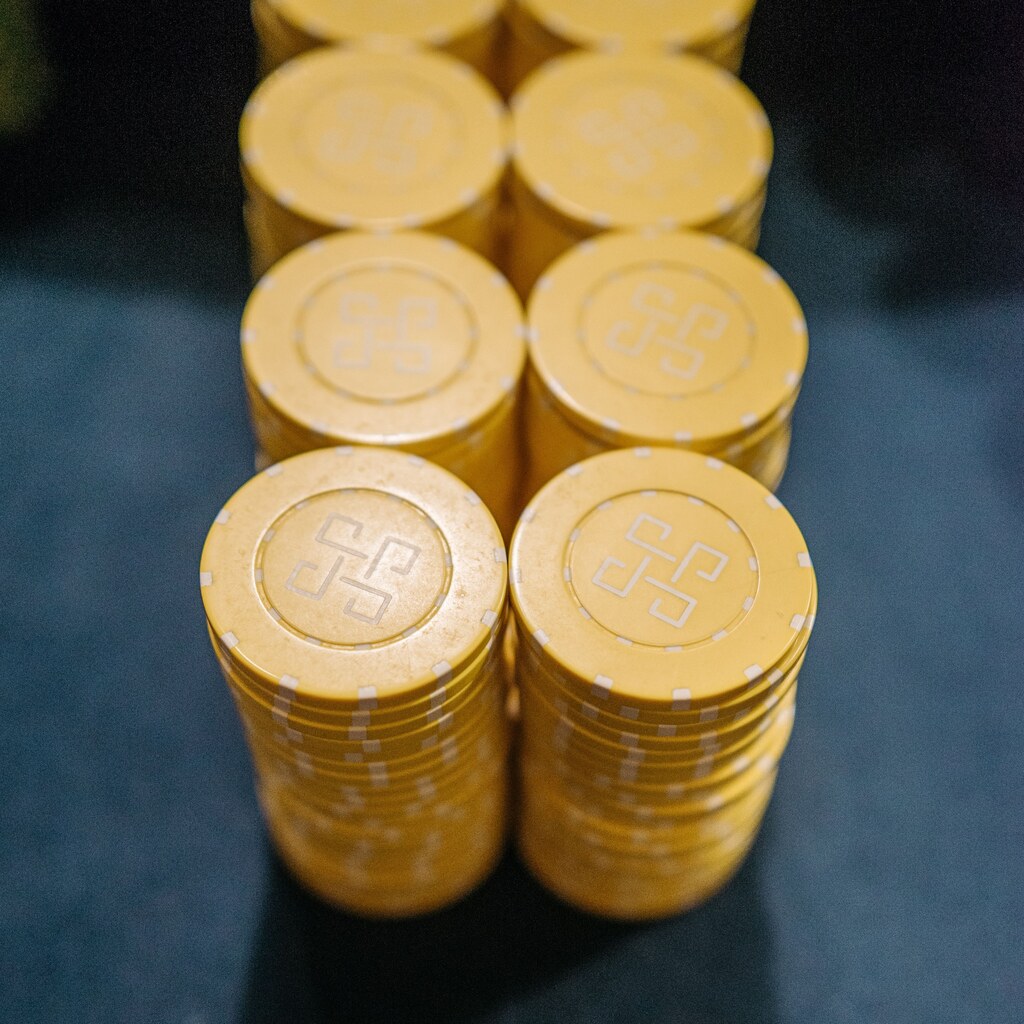 A photo of stacked yellow casino chips on a dark surface.