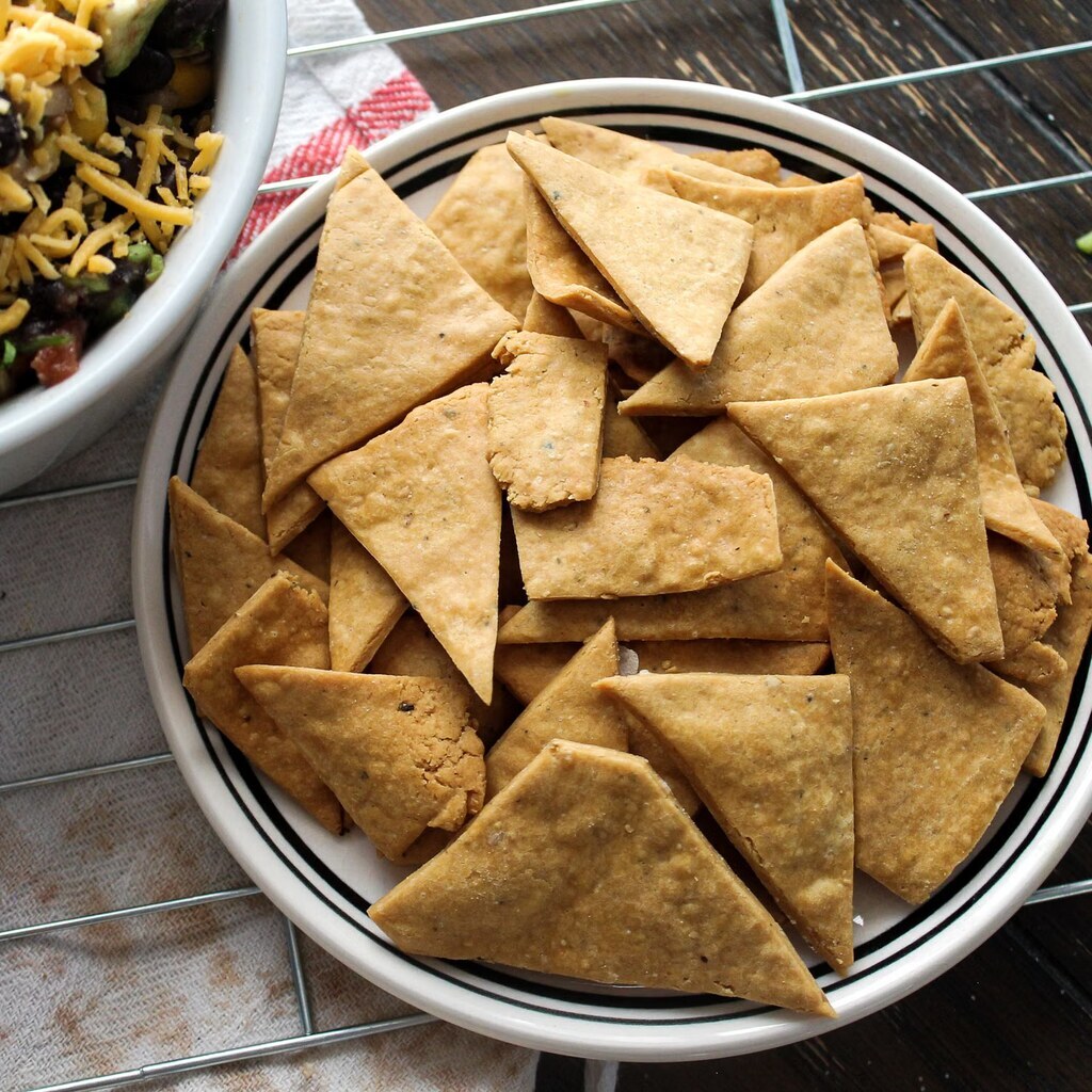 A photo of tortilla chips arranged on a white plate.