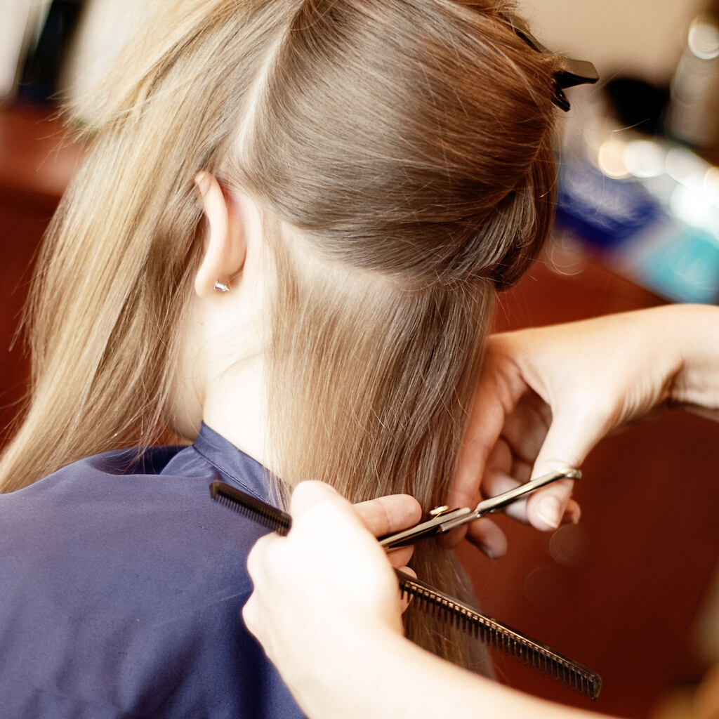 Photo of a girl having her hair trimmed