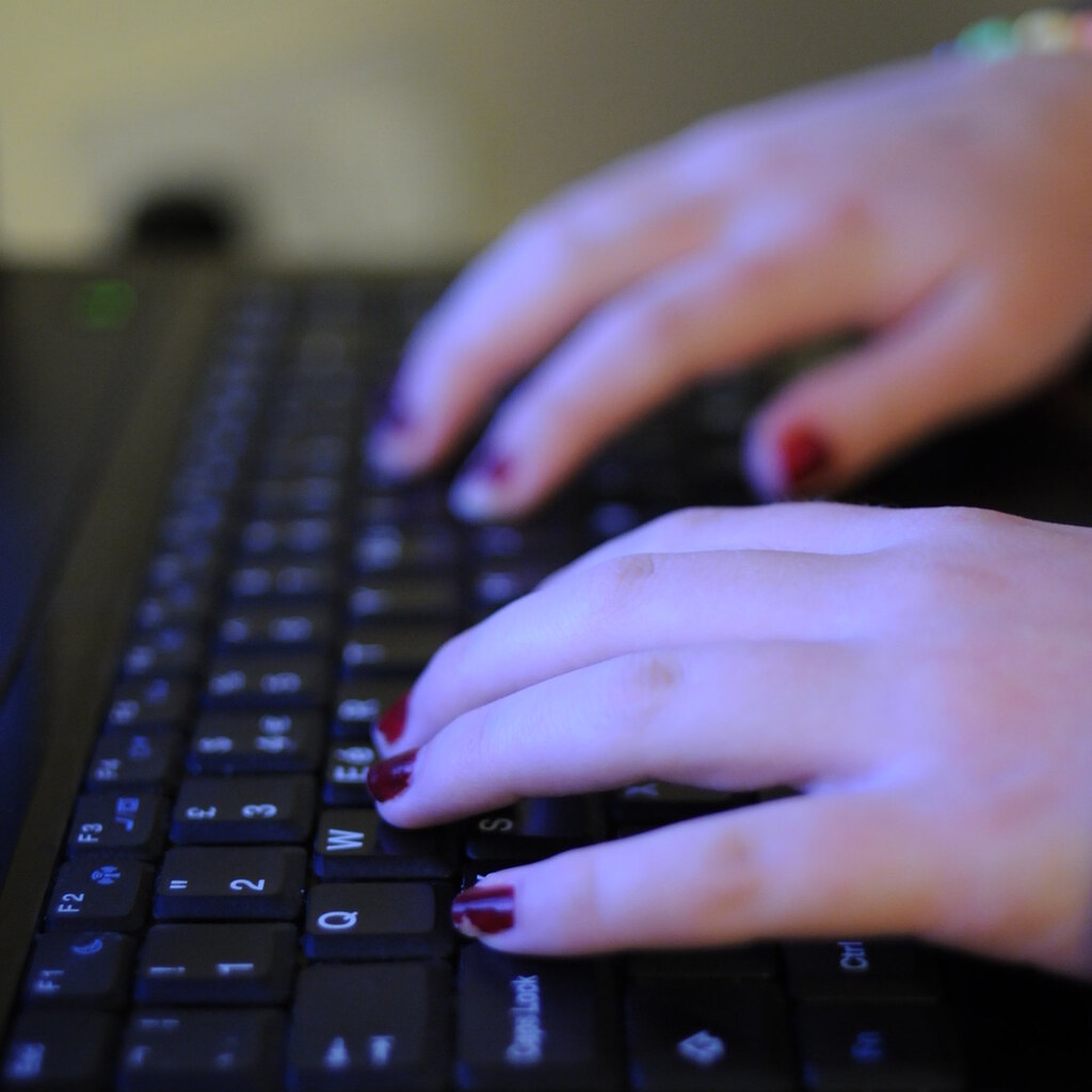 Photo of hands on a keyboard typing.