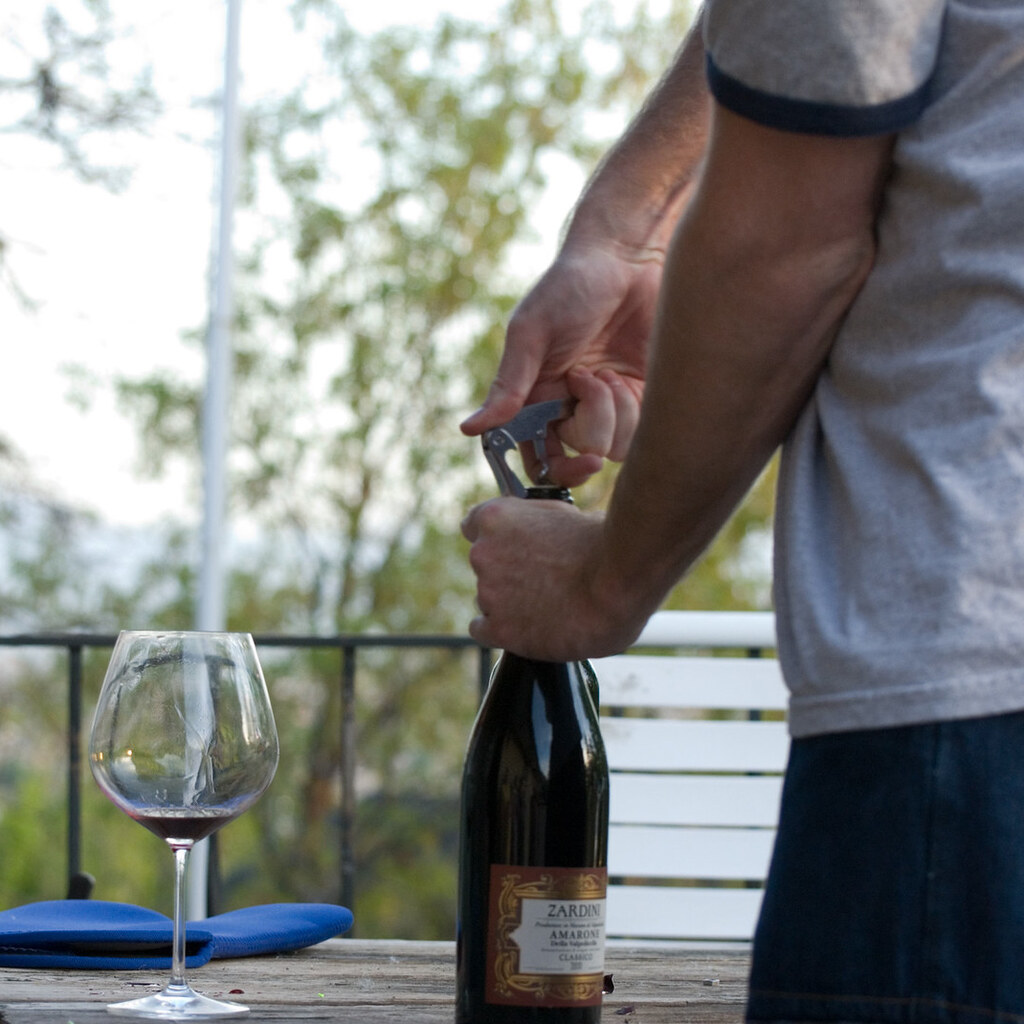 Photo of a man opening a bottle of wine