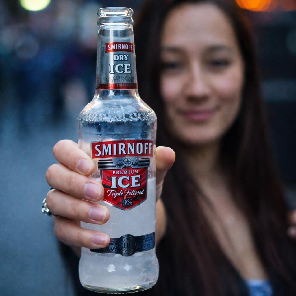 Photo of a woman holding a bottle of vodka