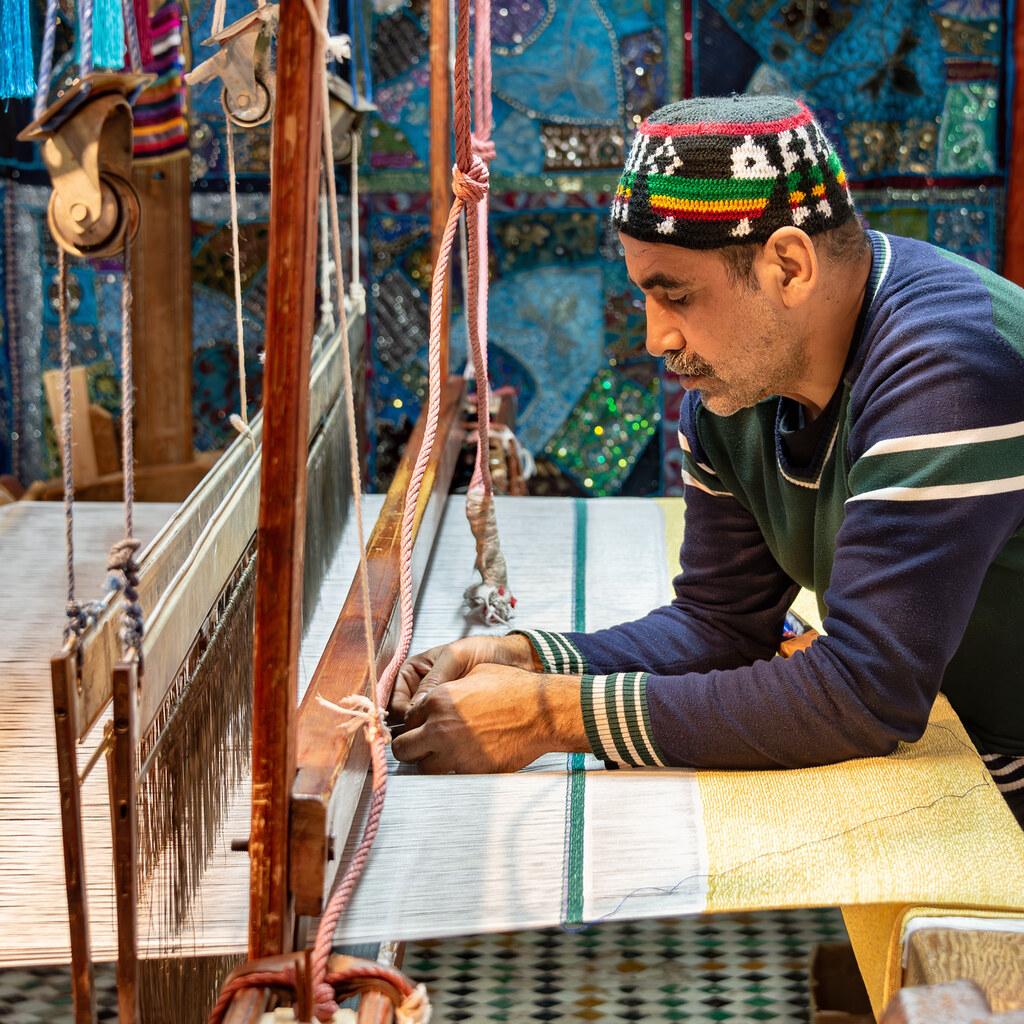Photo of a weaver at work on a loom